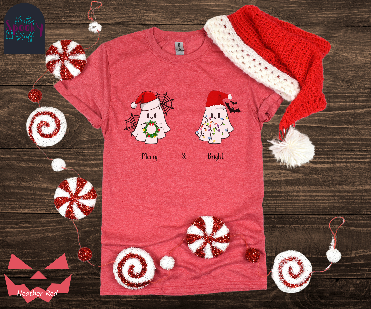 Christmas shirt with two ghosts wearing santa hats, one holding a wreath with spiderwebs behind them, and one tangled in lights with bats behind them, named Merry and Bright, in heather red.