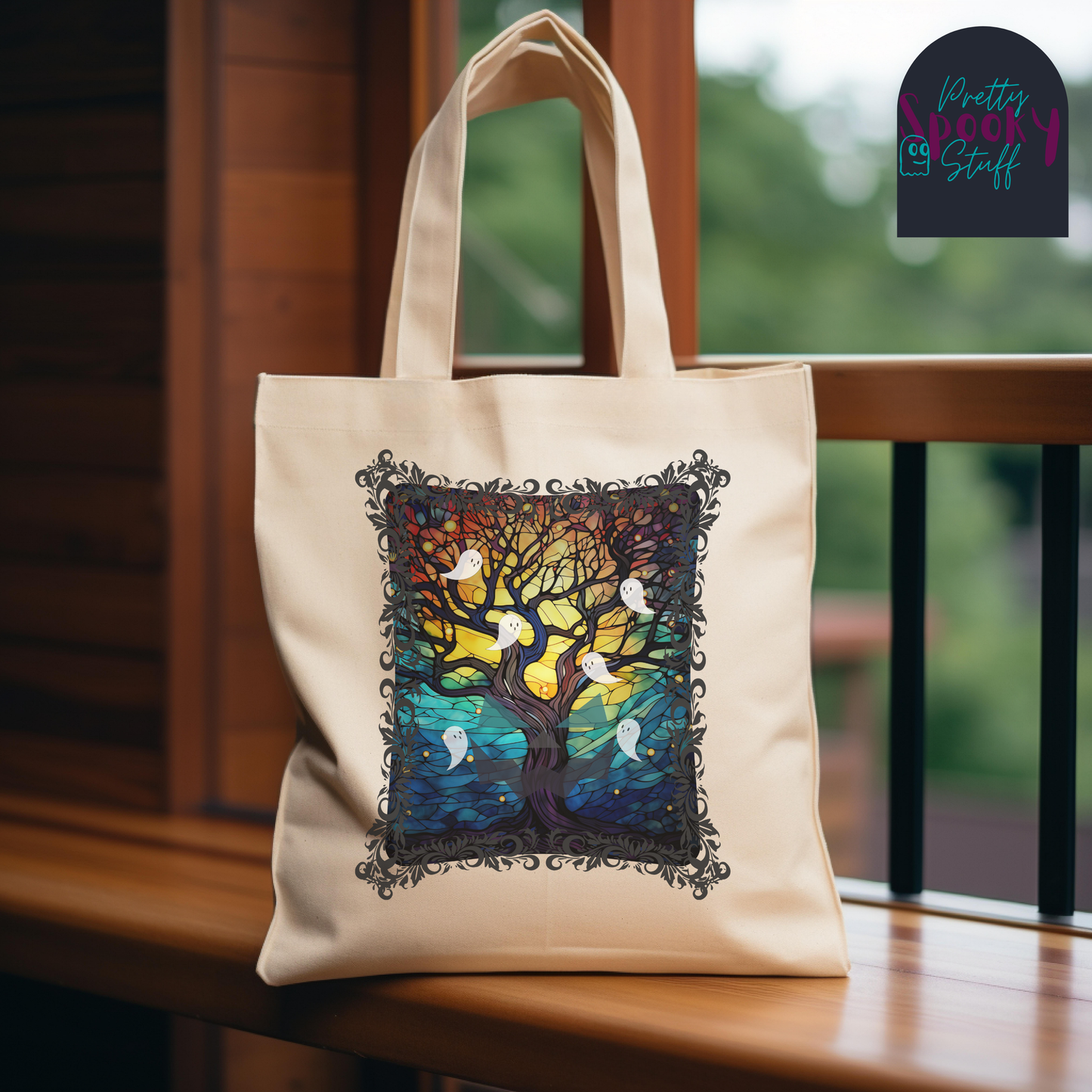 Halloween canvas tote bag with stained glass design featuring a bare brown tree reaching to the glowing moon with ghosts flying all around, natural background.