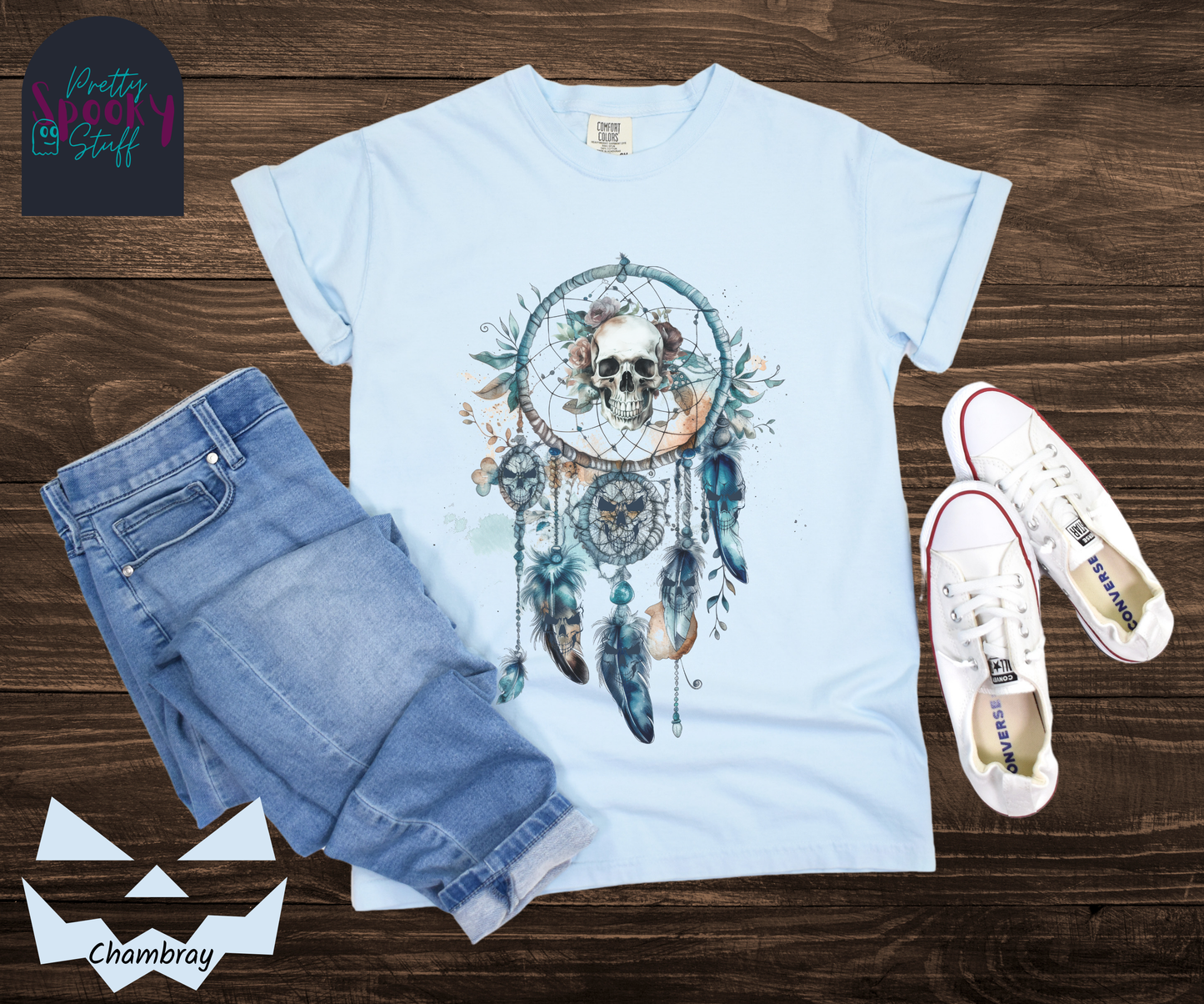 Halloween eerie skull dreamcatcher shirt, watercolor aesthetic in shades of blue, featuring a skull with blue tinted flowers in the main circle, and creepy skull faces hiding amongst the 4 feathers and 2 additional circles hanging below in chambray.