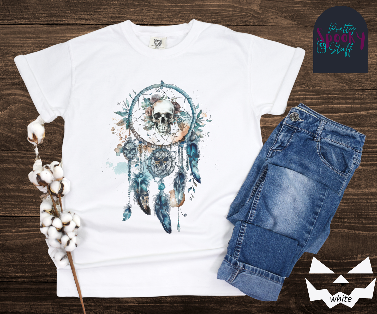 Halloween eerie skull dreamcatcher shirt, watercolor aesthetic in shades of blue, featuring a skull with blue tinted flowers in the main circle, and creepy skull faces hiding amongst the 4 feathers and 2 additional circles hanging below in white.
