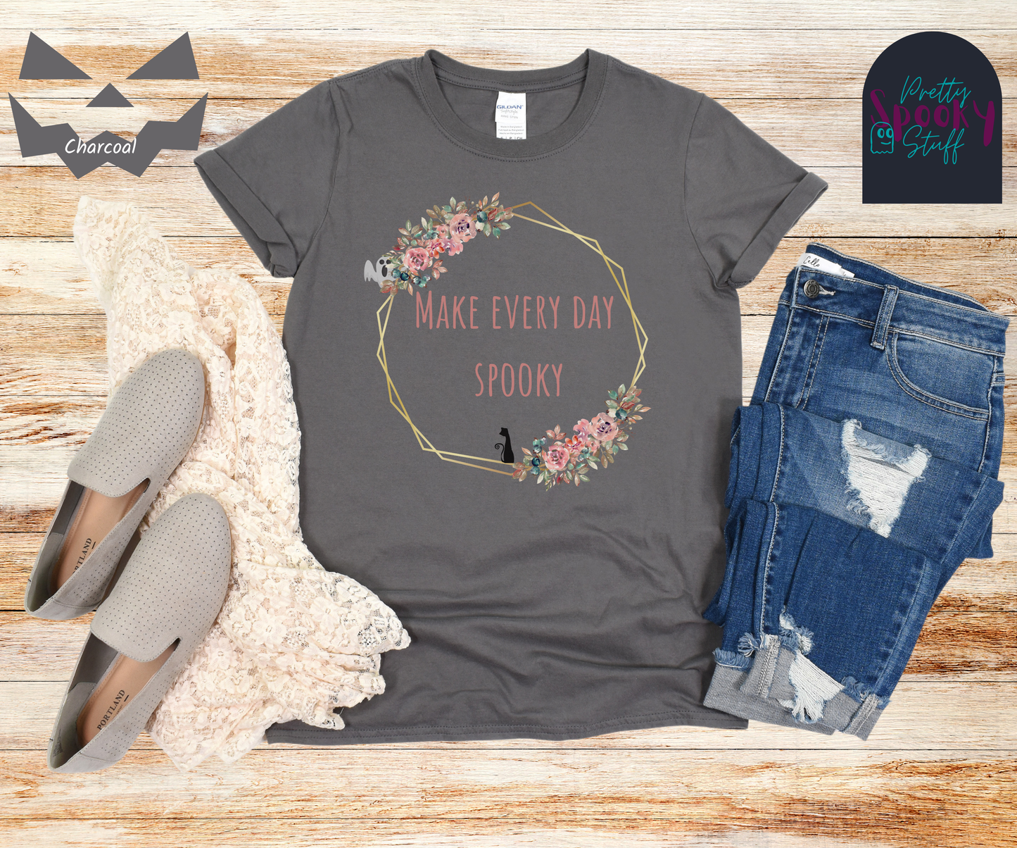 Typography shirt with the words "make every day spooky" in the middle of a gold circular frame with floral details and a black cat sitting on the bottom and a ghost peaking from the top, in charcoal.