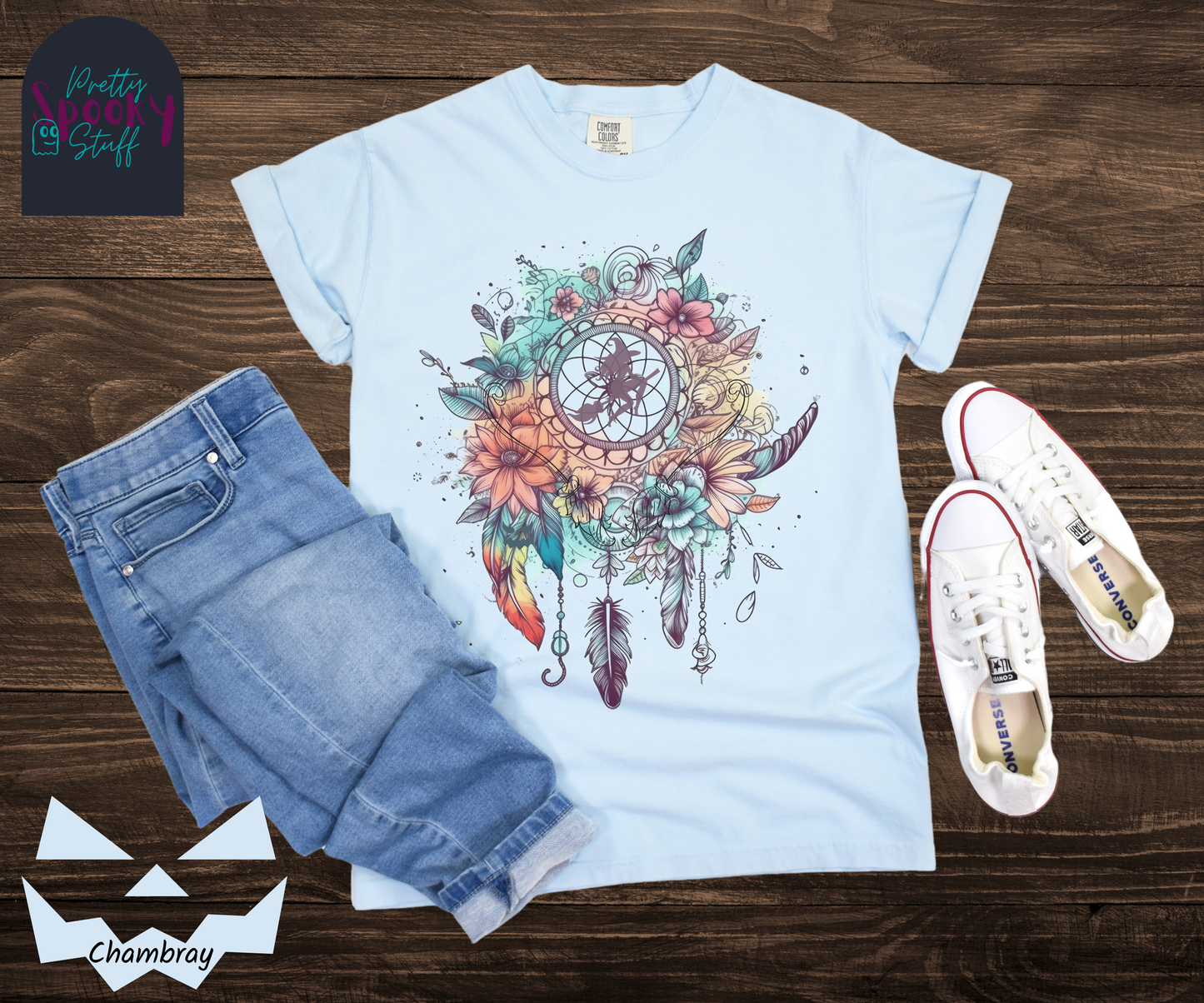 Halloween floral witch dreamcatcher shirt, watercolor aesthetic in blues and pinks, with purple silhouette of witch flying on her broom in the main circle, with witch broom line drawings hidden amongst the flowers, in chambray.
