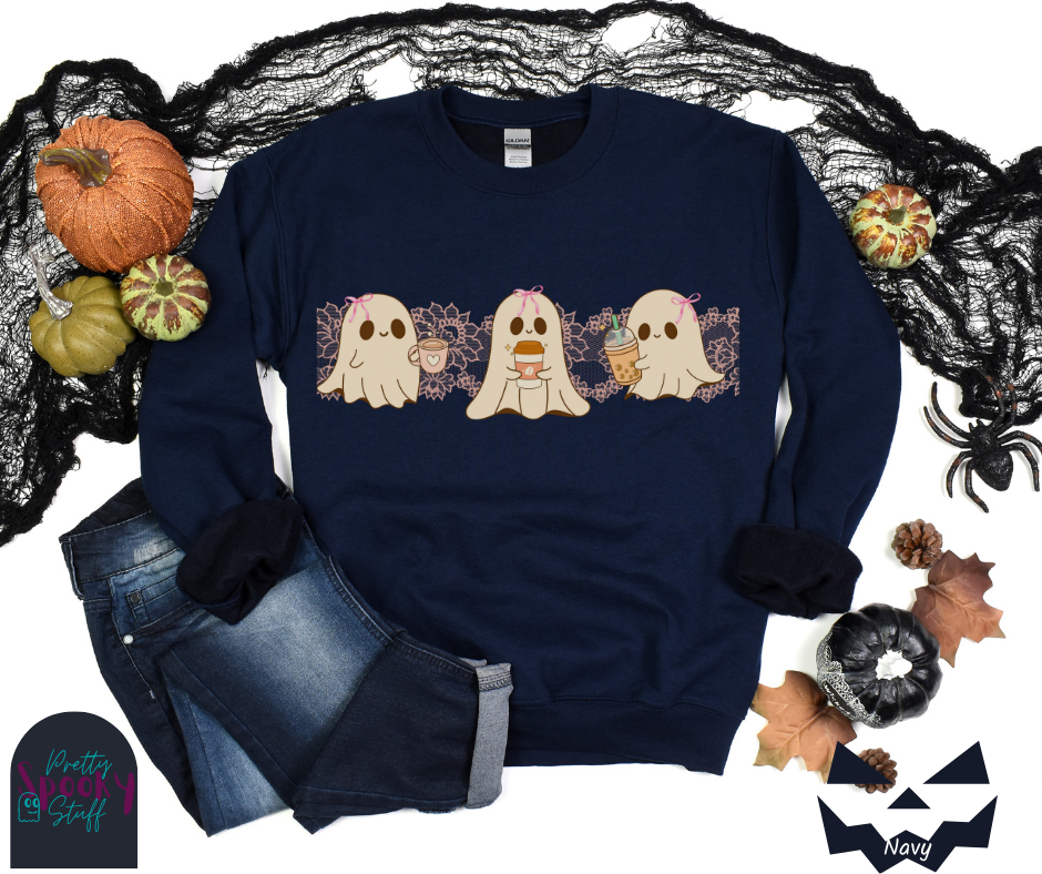 Coquette Halloween sweatshirt with three adorable ghosts, each enjoying their own coffee beverage, adorned with a pink bow, with light pink intricate lace design behind them, in navy.
