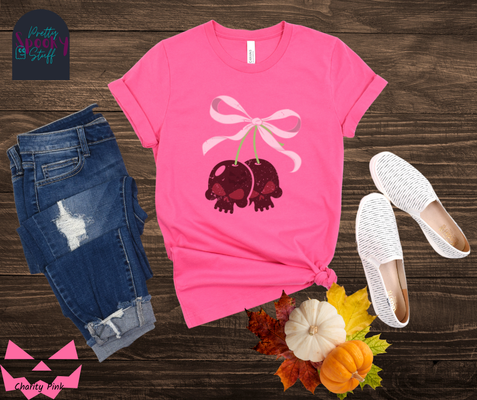 Halloween coquette shirt with a pair of cherries shaped as skulls, with a light pink bow tying them together, vintage look, in charity pink.