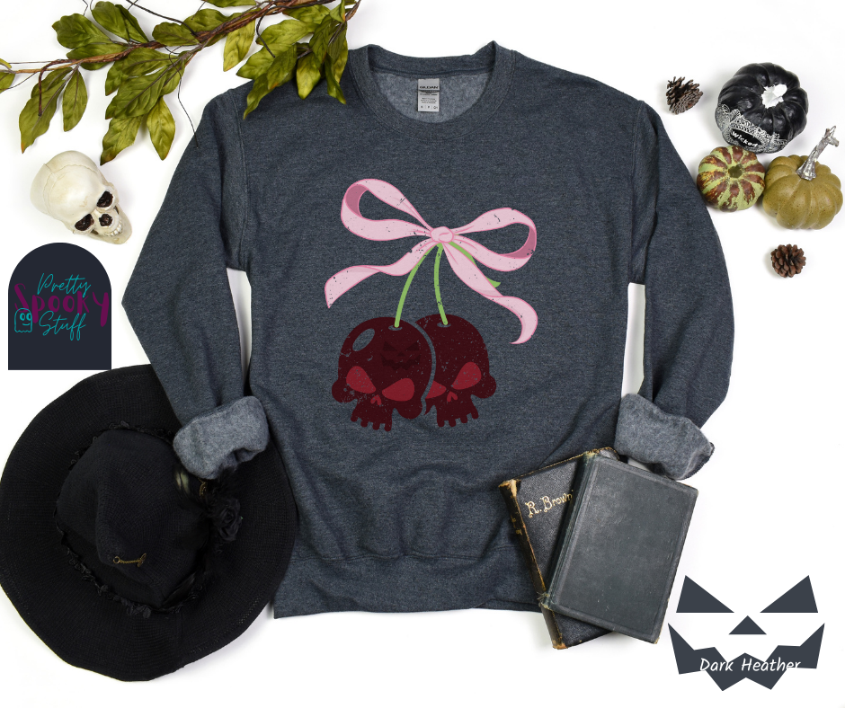 Coquette Halloween sweatshirt with two skull shaped cherries tied together with a large light pink bow, vintage style, in dark heather.