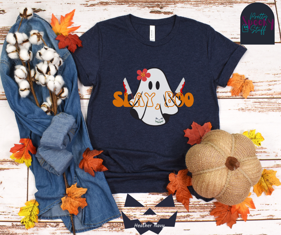 Ghost Halloween shirt with a ghost wearing pink flower, holding two bloody butcher knives and the words "slay boo" in orangle font in front of her, in heather navy.