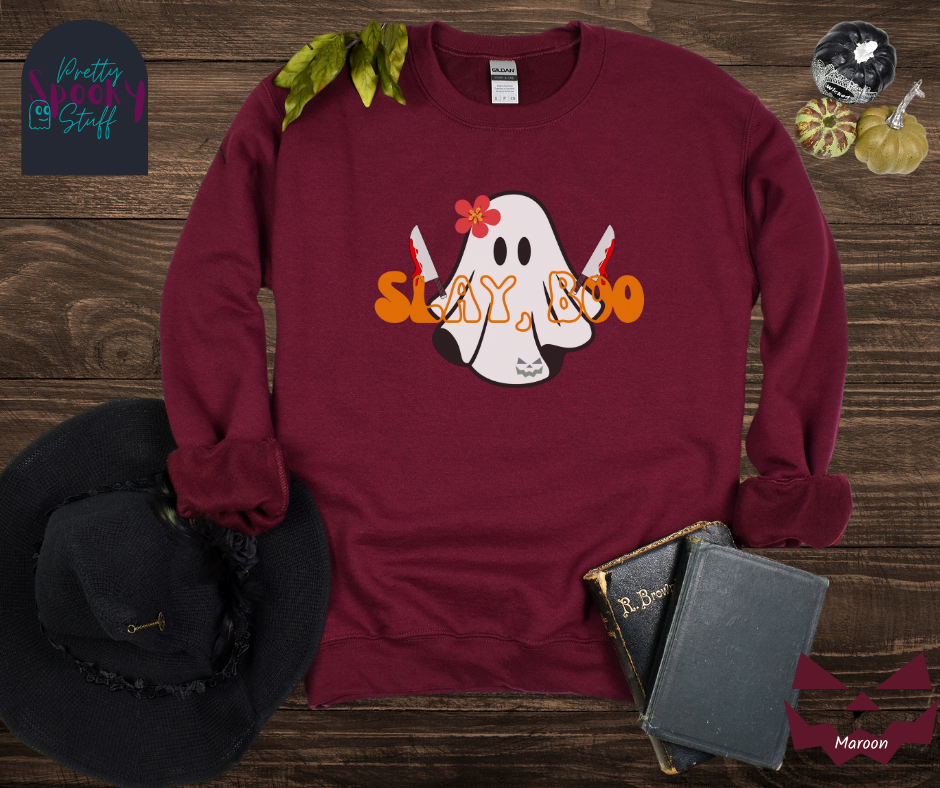 Ghost Halloween sweatshirt with a ghost wearing a pink flower on its head, holding two bloody knives, with the words "slay, boo" in orange vintage font in front, in maroon.