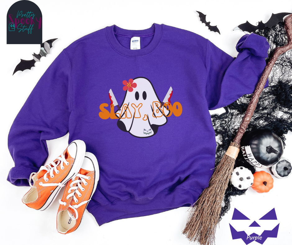 Ghost Halloween sweatshirt with a ghost wearing a pink flower on its head, holding two bloody knives, with the words "slay, boo" in orange vintage font in front, in purple.