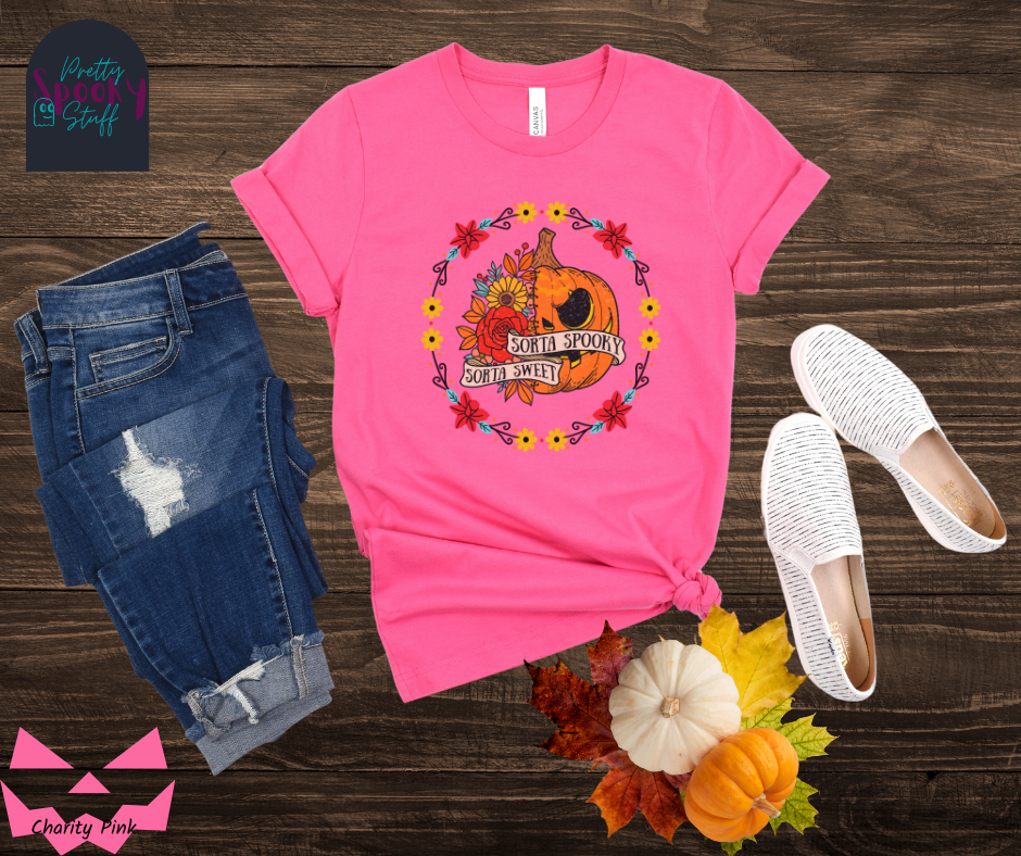 Pumpkin Halloween shirt with a circle of yellow, red, and blue flowers, surrounding a half jack o' lantern half floral design with the words "sorta sweet sorta spooky" on banners, in charity pink.