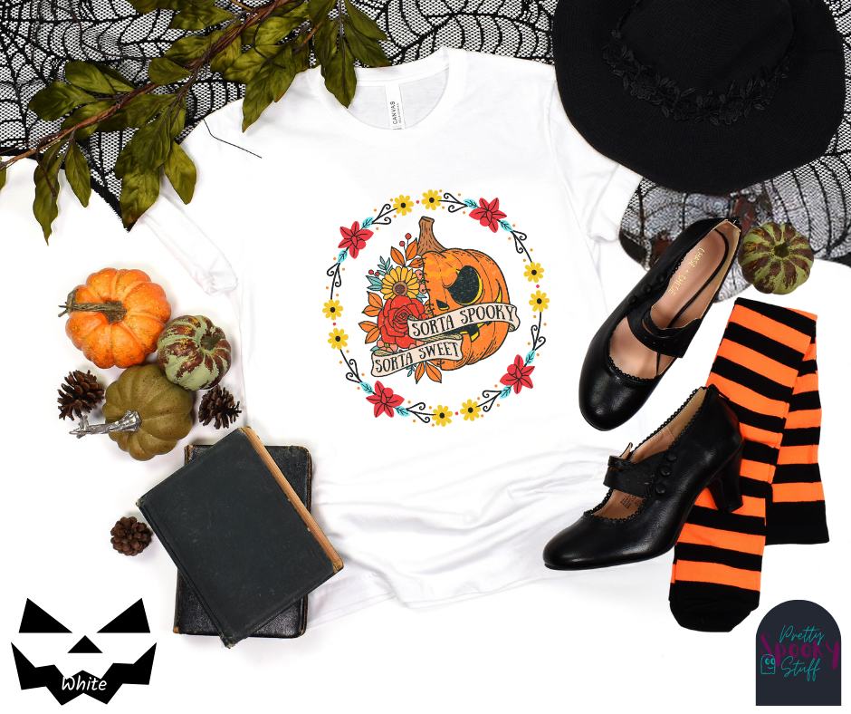 Pumpkin Halloween shirt with a circle of yellow, red, and blue flowers, surrounding a half jack o' lantern half floral design with the words "sorta sweet sorta spooky" on banners, in white.