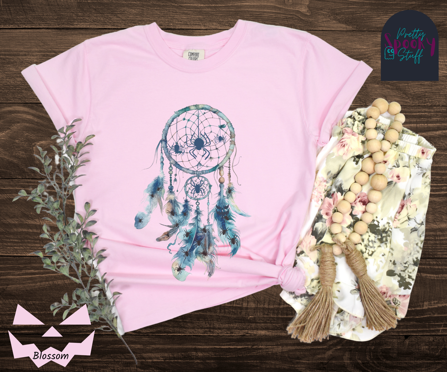 Halloween spider dreamcatcher shirt, watercolor aesthetic in shades of blue, a few spiders hanging in the main circle, several other spiders hiding in the multiple feathers hanging below, in blossom.