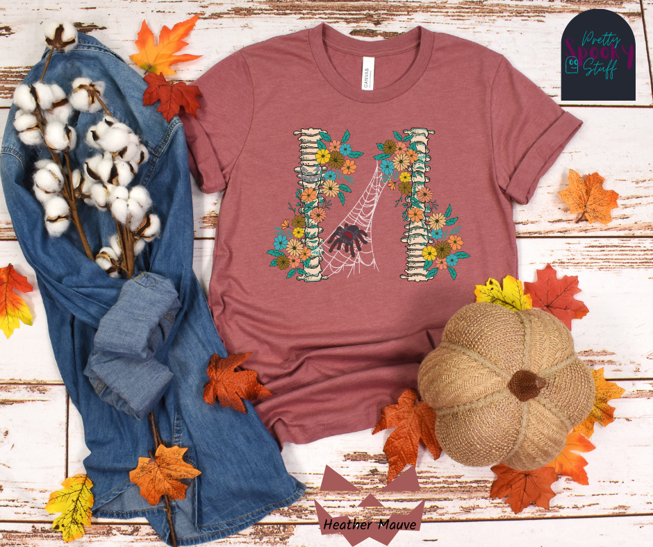 Spider Halloween shirt with two spine bones wrapped in vintage flowers, and a tarantula spider on a web between the two, in heather mauve.