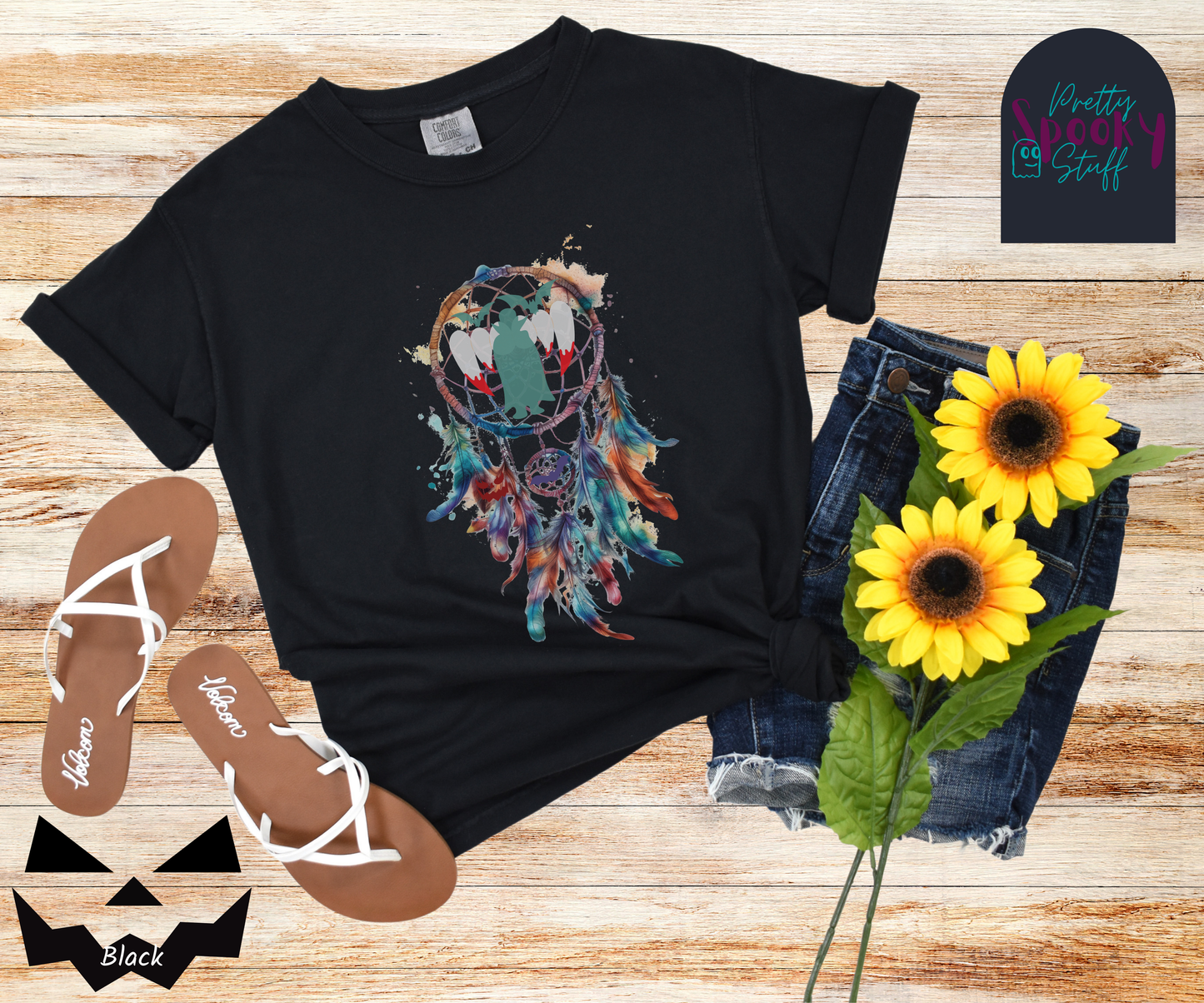 Halloween dream catcher shirt with watercolor aesthetic in blues and rusts, with teal vampire silhouette and bloody vampire teeth in main circle, bats and jack o' lantern face hidden amongst the several feathers hanging below, in black.