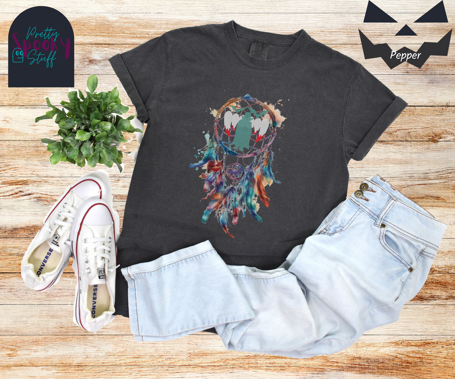 Halloween dream catcher shirt with watercolor aesthetic in blues and rusts, with teal vampire silhouette and bloody vampire teeth in main circle, bats and jack o' lantern face hidden amongst the several feathers hanging below, in pepper.