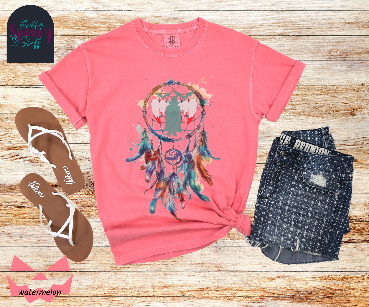Halloween dream catcher shirt with watercolor aesthetic in blues and rusts, with teal vampire silhouette and bloody vampire teeth in main circle, bats and jack o' lantern face hidden amongst the several feathers hanging below, in watermelon.