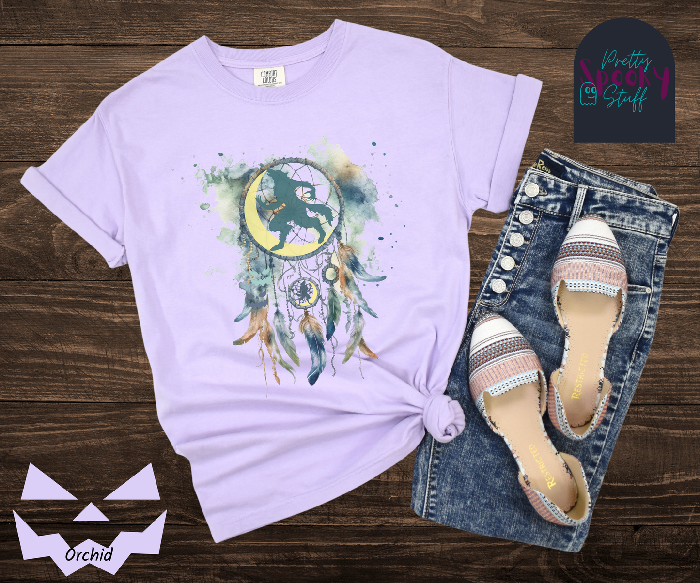 Halloween werewolf dreamcatcher shirt, watercolor aesthetic in blues and browns, featuring teal howling werewolf silhouette with yellow crescent moon in the main circle, with another werewolf/moon and jack o' lantern hiding amongst the several feathers and small circle hanging below, in orchid.