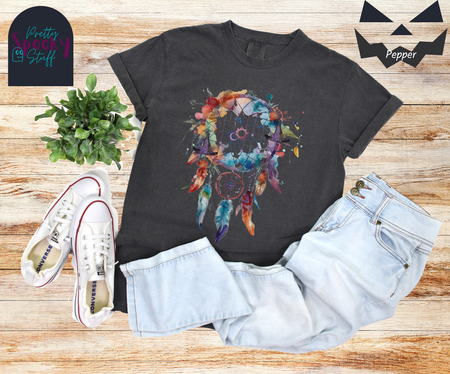 Witch Halloween dreamcatcher shirt, watercolor aesthetic in bright colors, moon and stars detail in the main circle with purple witch hats around the edge, 3 feathers and one smaller circle hanging below, in pepper.