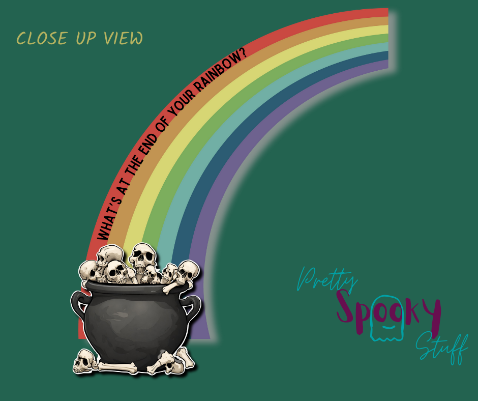 St. Patrick's Day shirt design closeup with a half rainbow coming out of a cauldron filled with bones, with the words "what's at the end of your rainbow" following the curve of the red line.