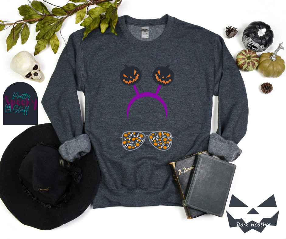 Halloween sweatshirt with aviator sunglasses filled with pumpkins and ghosts, and a purple headband with creepy jack o' lanterns, in dark heather.