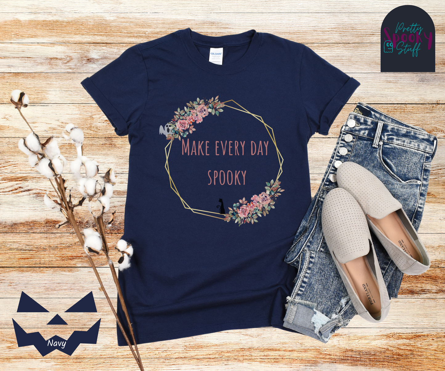 Typography shirt with the words "make every day spooky" in the middle of a gold circular frame with floral details and a black cat sitting on the bottom and a ghost peaking from the top, in navy.