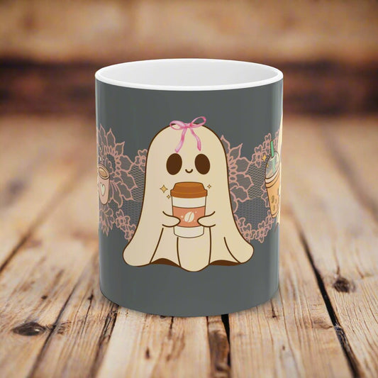 Ceramic Halloween coffee mug with three adorable ghosts, each enjoying their own coffee beverage, adorned with a pink bow, with light pink intricate lace design behind them, gray background.