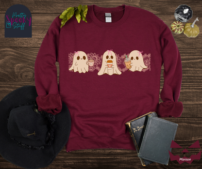Coquette Halloween sweatshirt with three adorable ghosts, each enjoying their own coffee beverage, adorned with a pink bow, with light pink intricate lace design behind them, in maroon.