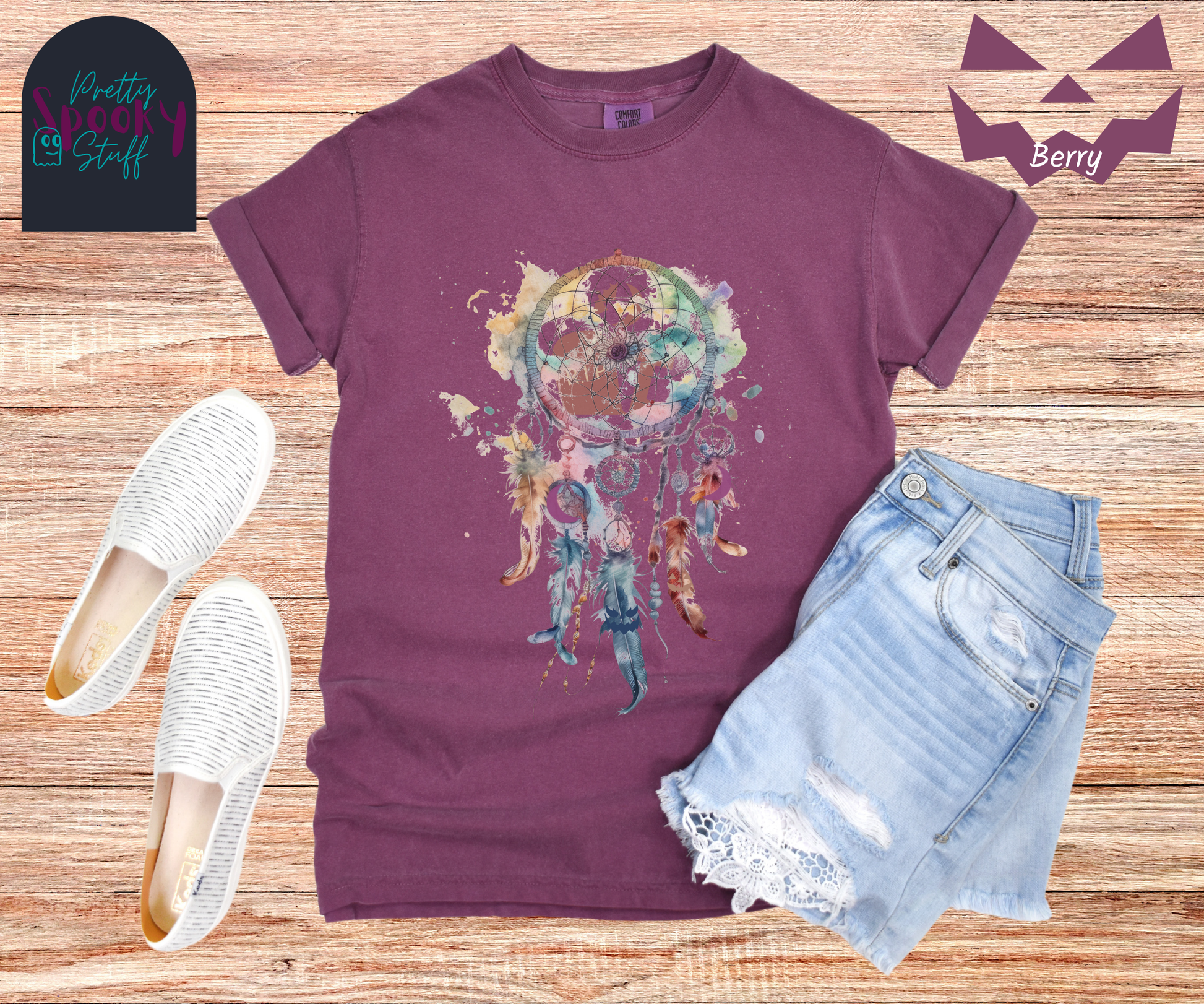Gravestone dream catcher shirt, watercolor aesthetic dream catcher with blues, pinks and purples, 5 feathers hanging blow, mauve gravestones in main circle, and crescent moons hidden in feathers, in berry.