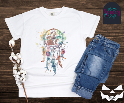 Gravestone dream catcher shirt, watercolor aesthetic dream catcher with blues, pinks and purples, 5 feathers hanging blow, mauve gravestones in main circle, and crescent moons hidden in feathers, in white.