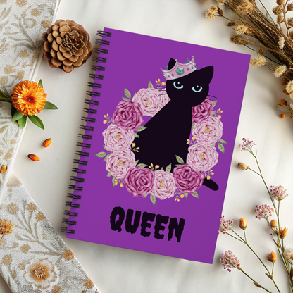 Spooky Girl Summer spiral notebook featuring black cat sitting in ring of pink and purple roses, wearing a crooker crown with the word "queen" below in black, with purple background.