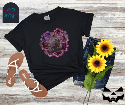 Summerween shirt with flowers of different shades of purple arranged in the shape of a heart, with shadows of running zombies and two zombie arm line drawings mixed in, in black.