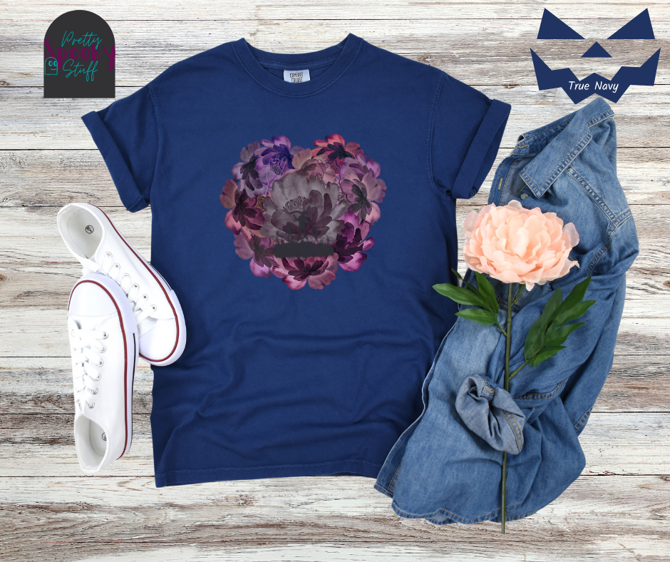 Summerween shirt with flowers of different shades of purple arranged in the shape of a heart, with shadows of running zombies and two zombie arm line drawings mixed in, in true navy.