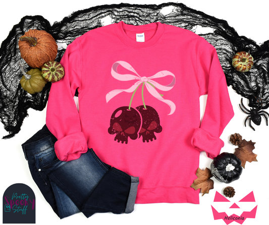 Coquette Halloween sweatshirt with two skull shaped cherries tied together with a large light pink bow, vintage style, in heliconia.