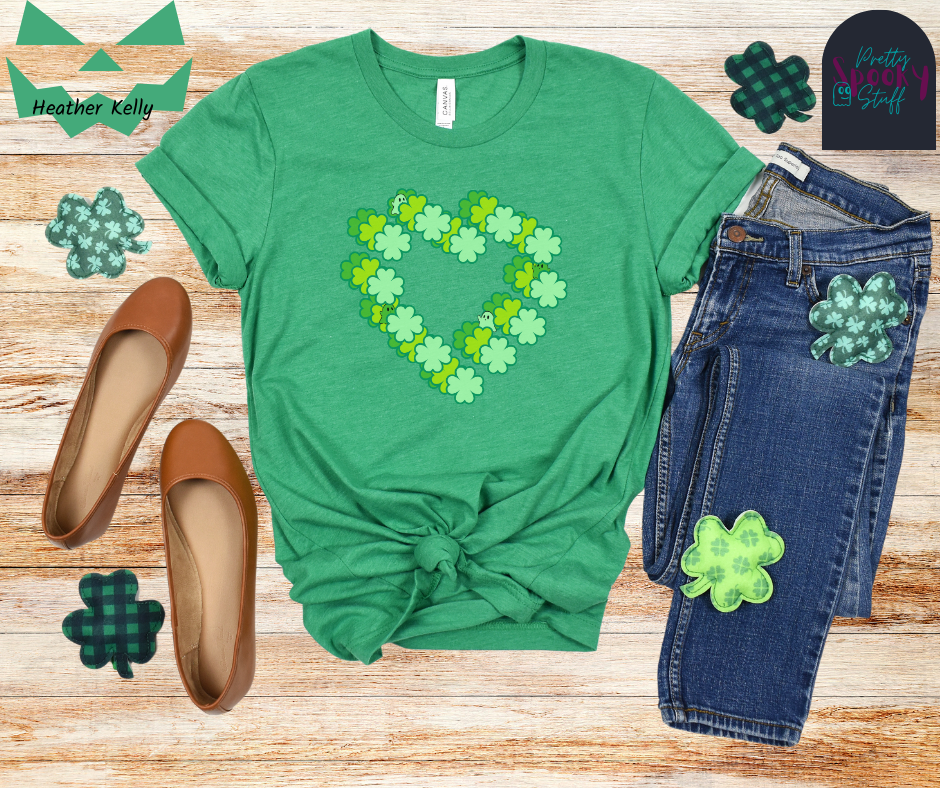 St. Patrick's Day shirt with three hearts made from four-leaf clovers, each in a different shade of green, offset from each other with ghosts hiding amongst them in shades of green, in heather kelly.