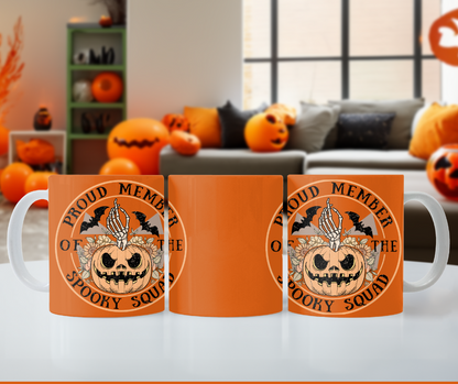 Halloween ceramic mug with a skeleton hand coming out of a jack o lantern with flowers behind it, two bats above it, surrounded by the words "proud member of the spooky squad" in a circle, orange background, 3 side view.