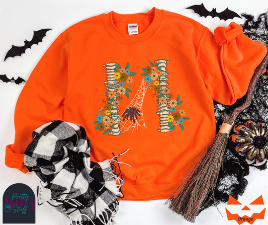 Spider Halloween sweatshirt with two spine bones wrapped in vintage flowers, and a tarantula spider on a web between the two, in orange.