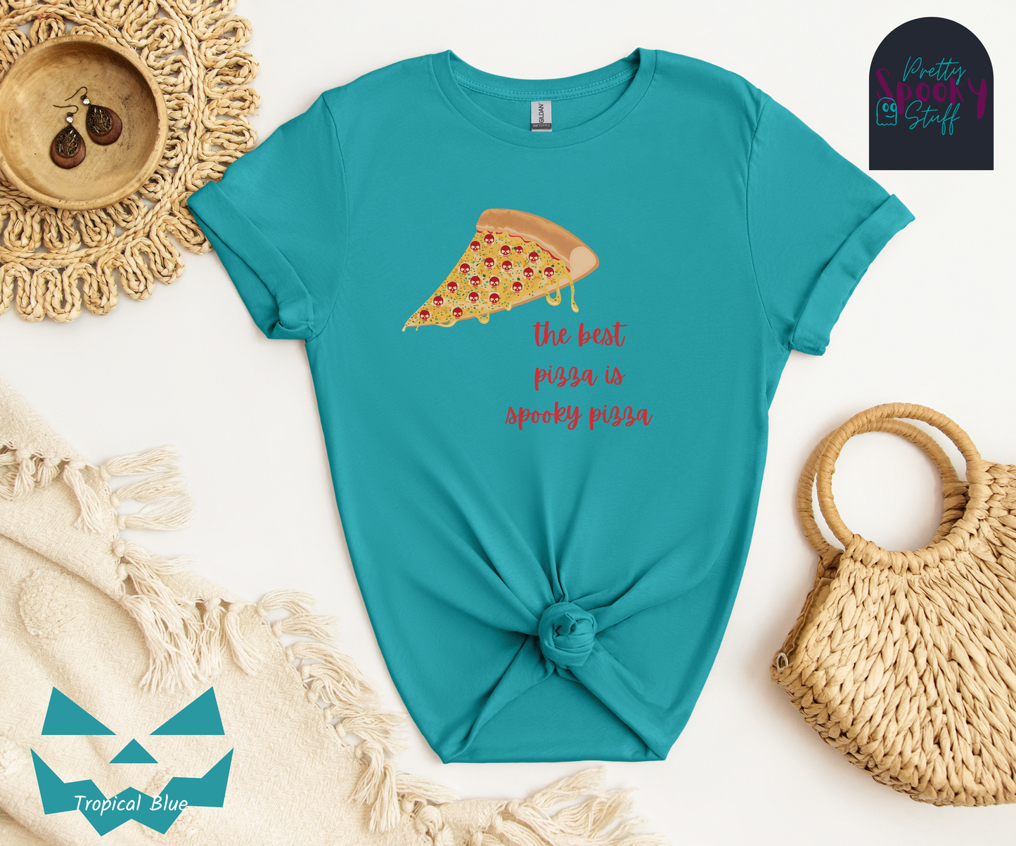 Pizza shirt with a slice of pepperoni pizza with skull shaped pepperonis and the words "the best pizza is spooky pizza" in red cursive font, in tropical blue.