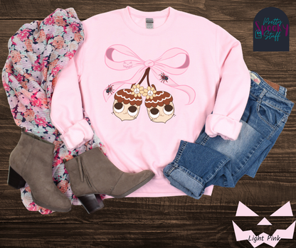 Fall coquette vintage sweatshirt with large pink bow that ties twin acorn characters together, two spiders on the bow, acorns having cutesy faces, in light pink.