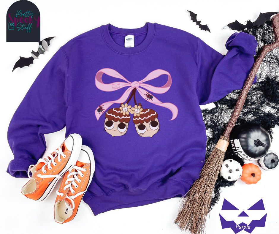 Fall coquette vintage shirt with large pink bow that ties twin acorn characters together, two spiders on the bow, acorns having cutesy faces, in purple.