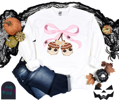 Fall coquette vintage shirt with large pink bow that ties twin acorn characters together, two spiders on the bow, acorns having cutesy faces, in white.