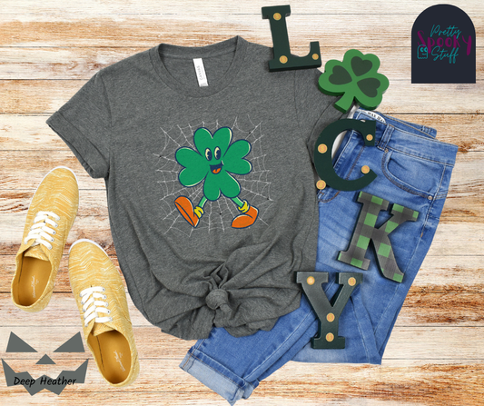 St. Patrick's Day shirt with four-leaf clover character on a spiderweb background with small spiders around it, in deep heather.